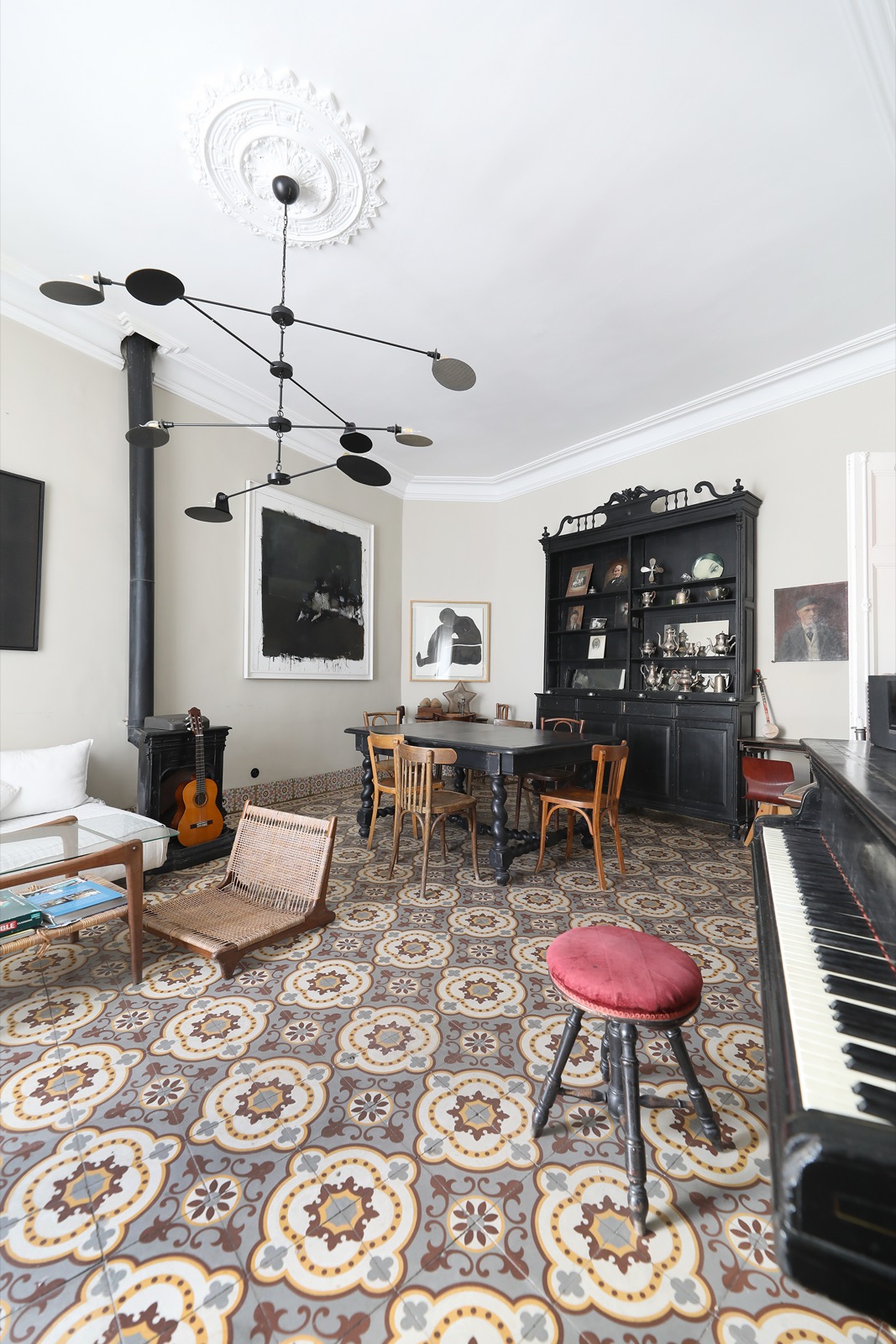 Le coin musique du salon &mdash; le piano à queue, le poêle noir et la guitare sous les œuvres