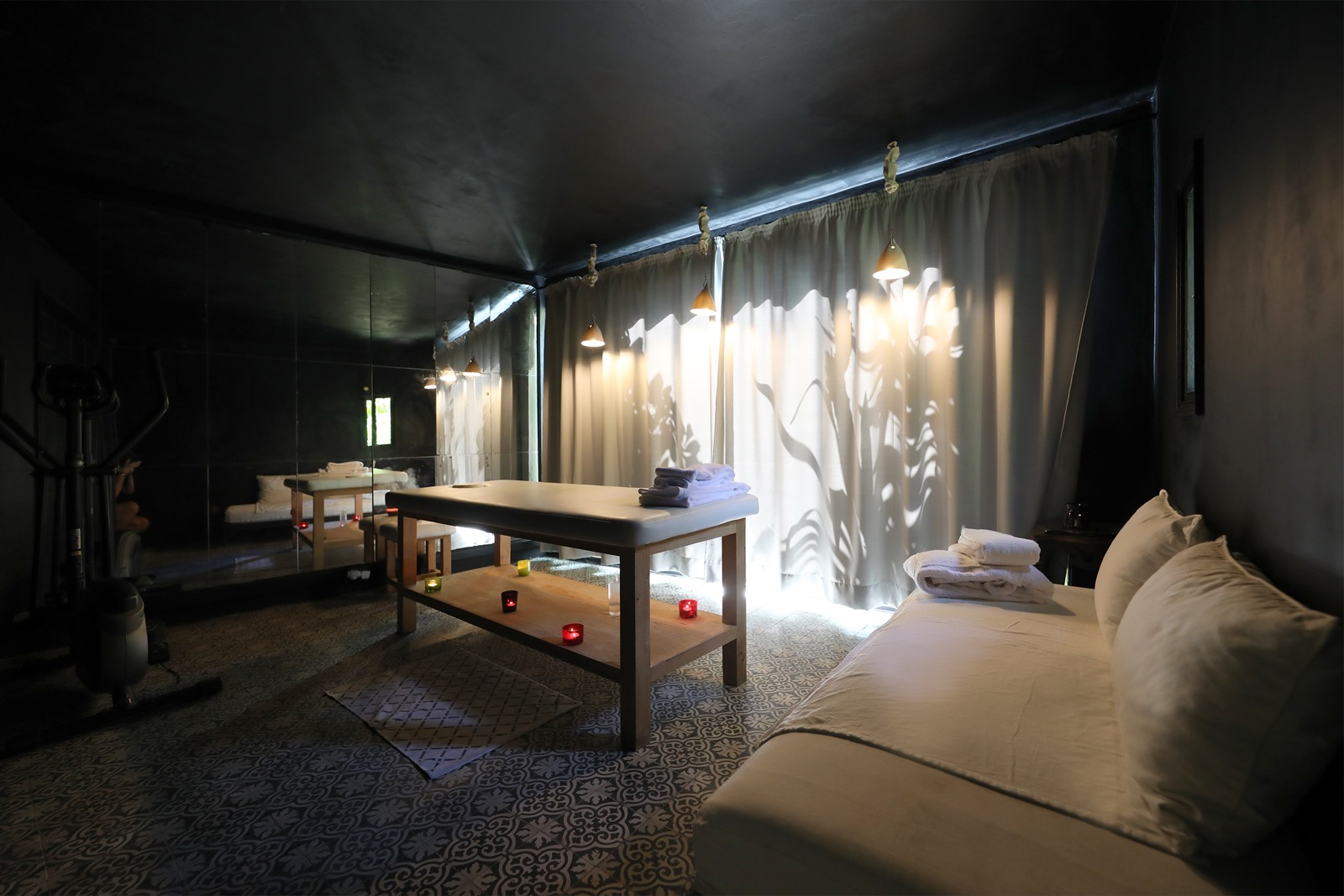 Le salon de massage de Mimi Calpe &mdash; table de soin, bougies et lumière tamisée par le rideau